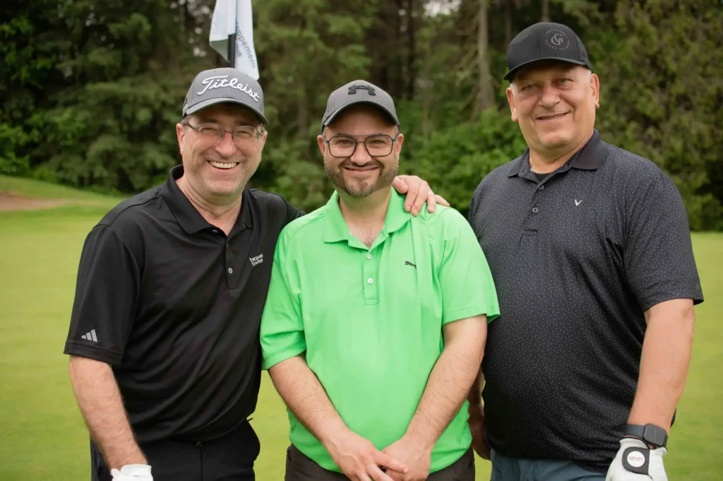 Trois golfeurs souriants sur un parcours verdoyant