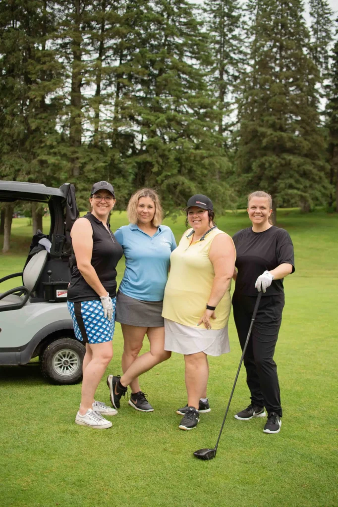 Quatre femmes posant sur un parcours de golf