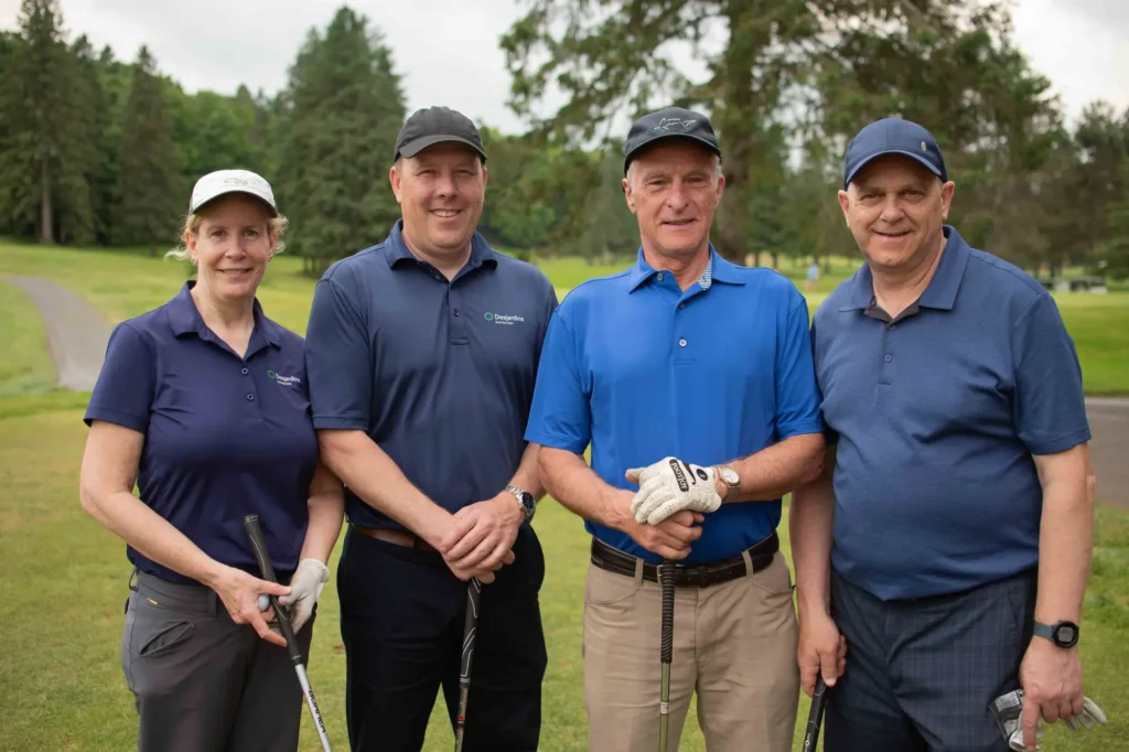 Quatre golfeurs posant sur un parcours verdoyant
