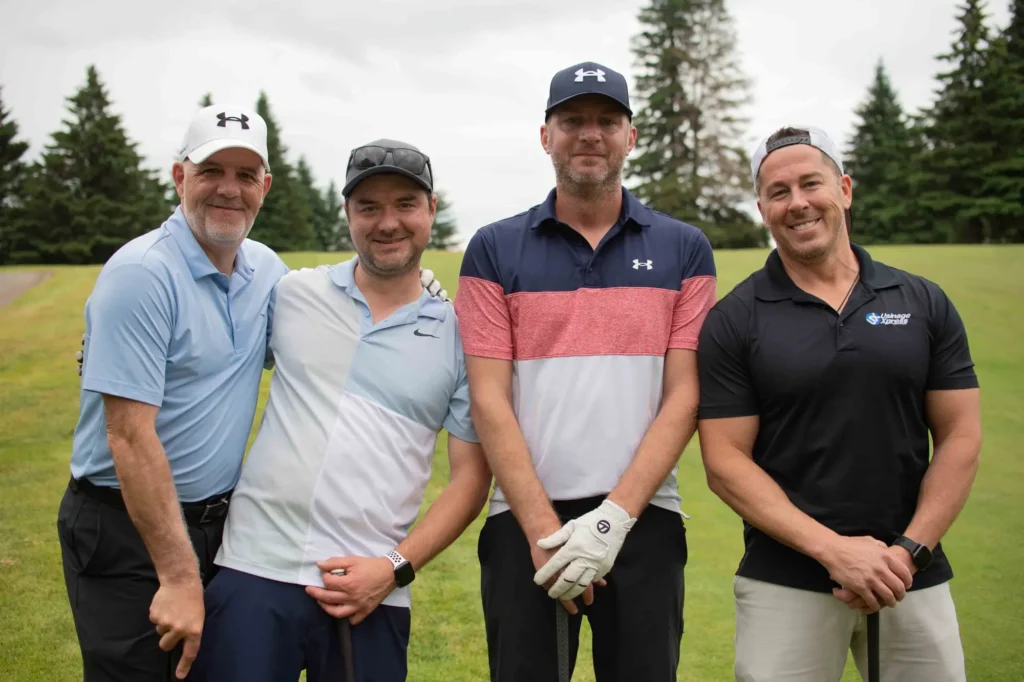 Quatre hommes posent sur un terrain de golf