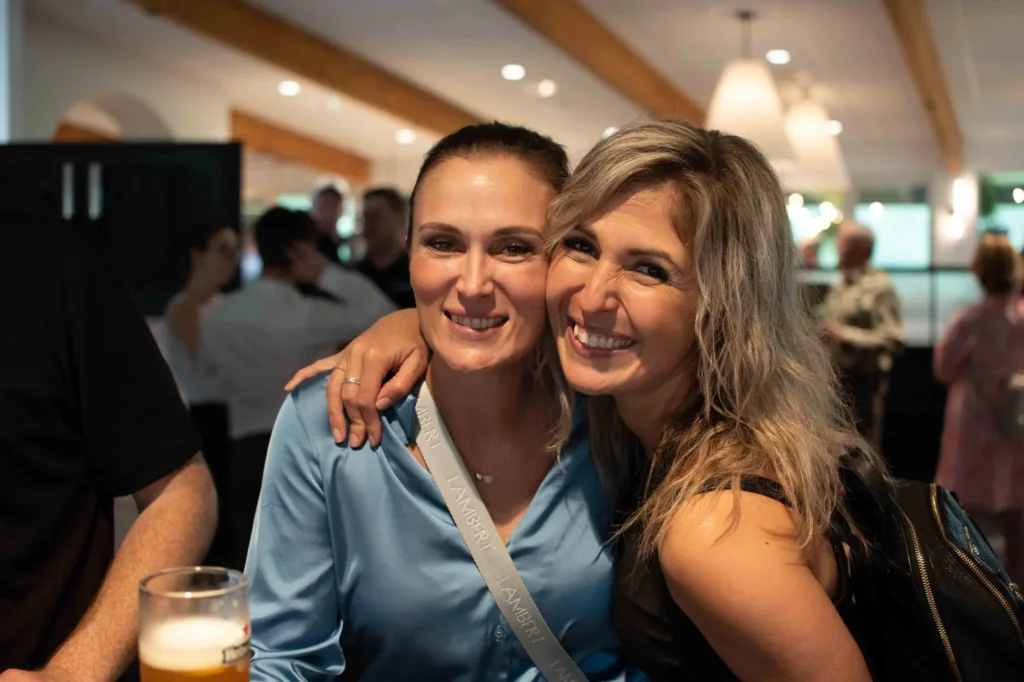 Deux femmes souriantes enlacées dans un bar