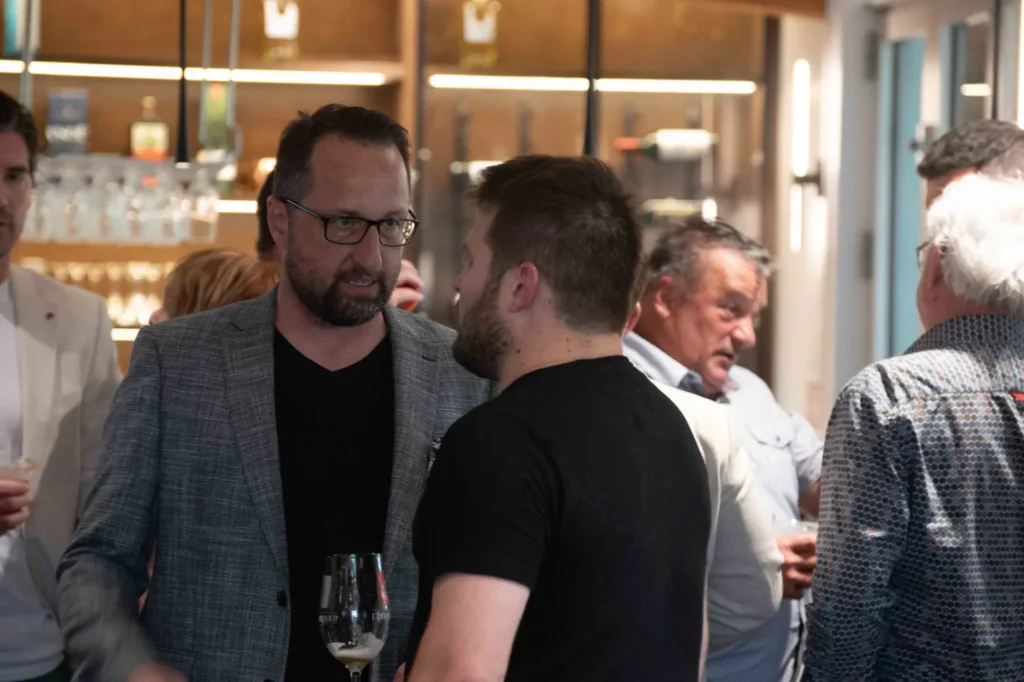 Hommes discutant lors d’un cocktail en intérieur