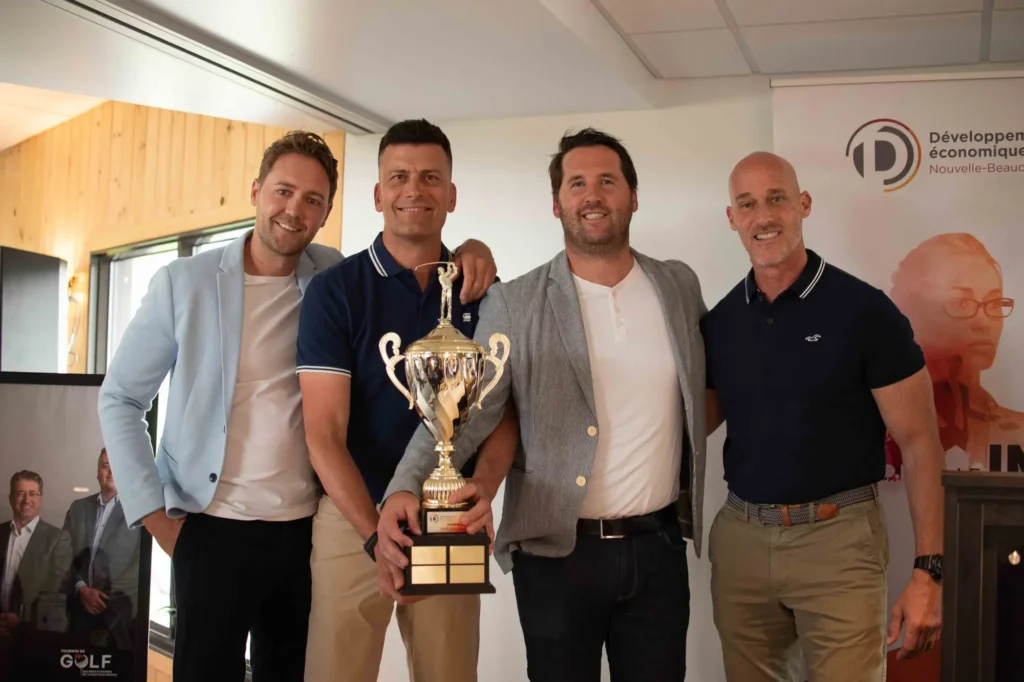 Quatre hommes posent avec un trophée de golf