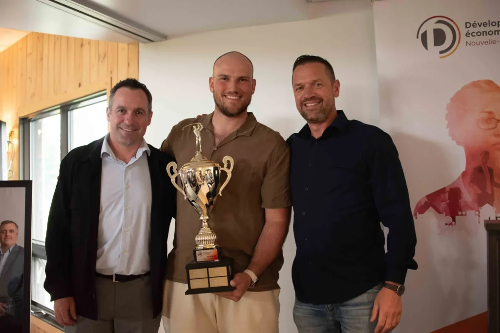 Trois hommes posent avec un trophée